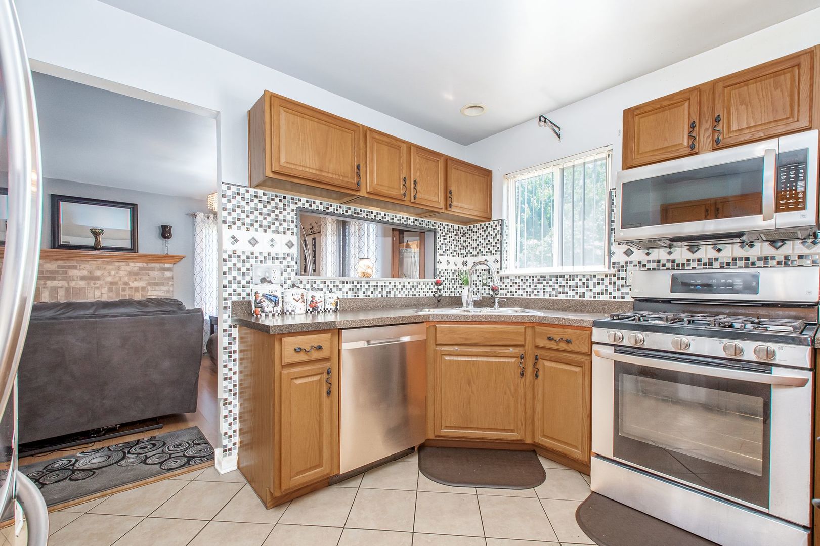 1925 Tilson Lane Romeoville, IL 60446 - Photo 14 of 27 a kitchen with stainless steel appliances granite countertop a stove a sink and a microwave