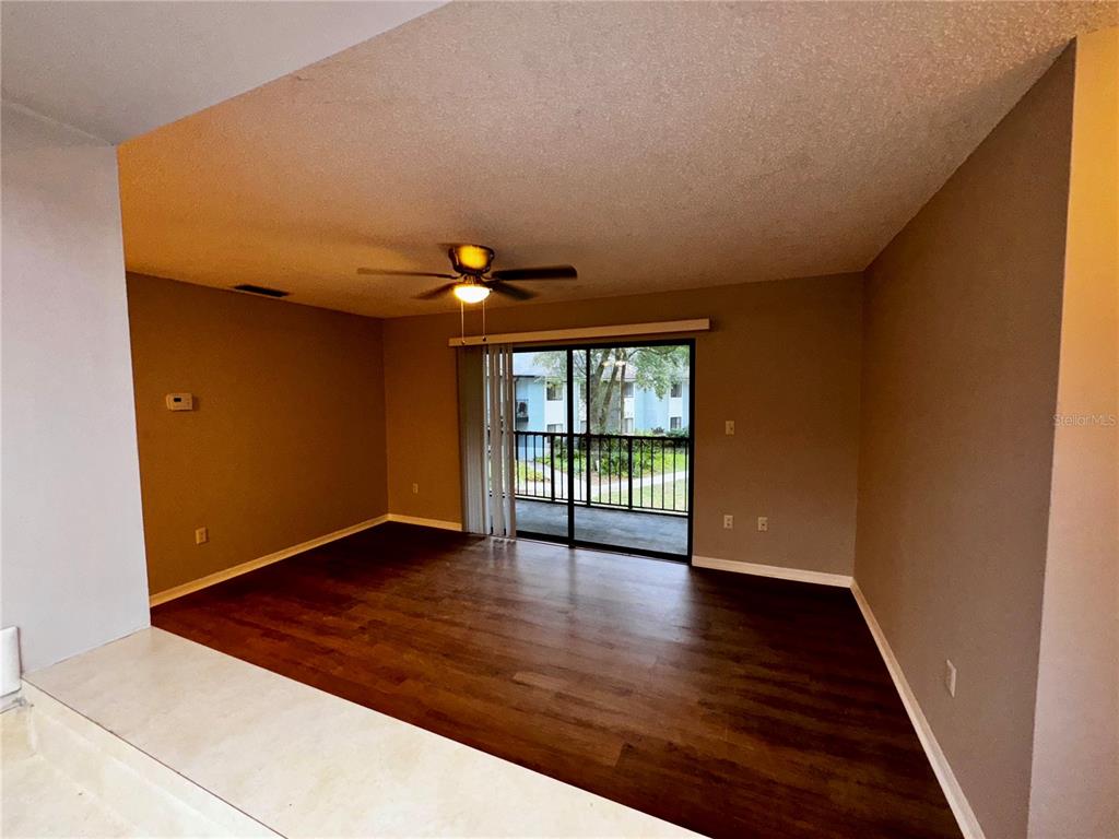 180 Waterfall Way, Unit 203 Altamonte Springs, FL 32714 - Photo 11 of 26 a view of an empty room with wooden floor and a window