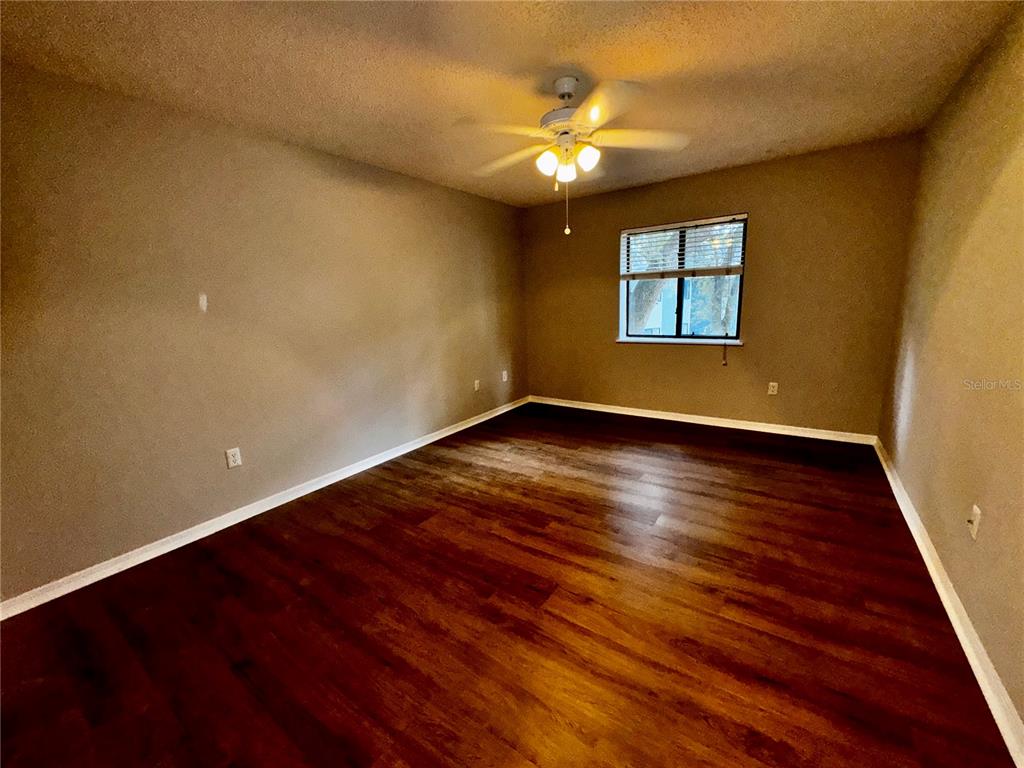 180 Waterfall Way, Unit 203 Altamonte Springs, FL 32714 - Photo 15 of 26 a view of an empty room with wooden floor and a window