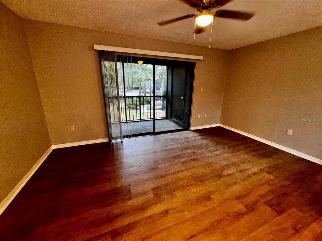 180 Waterfall Way, Unit 203 Altamonte Springs, FL 32714 - Photo 4 of 26 a view of an empty room with wooden floor and a window