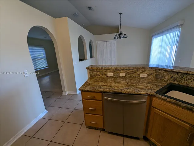a kitchen with stainless steel appliances granite countertop a refrigerator a sink and a stove