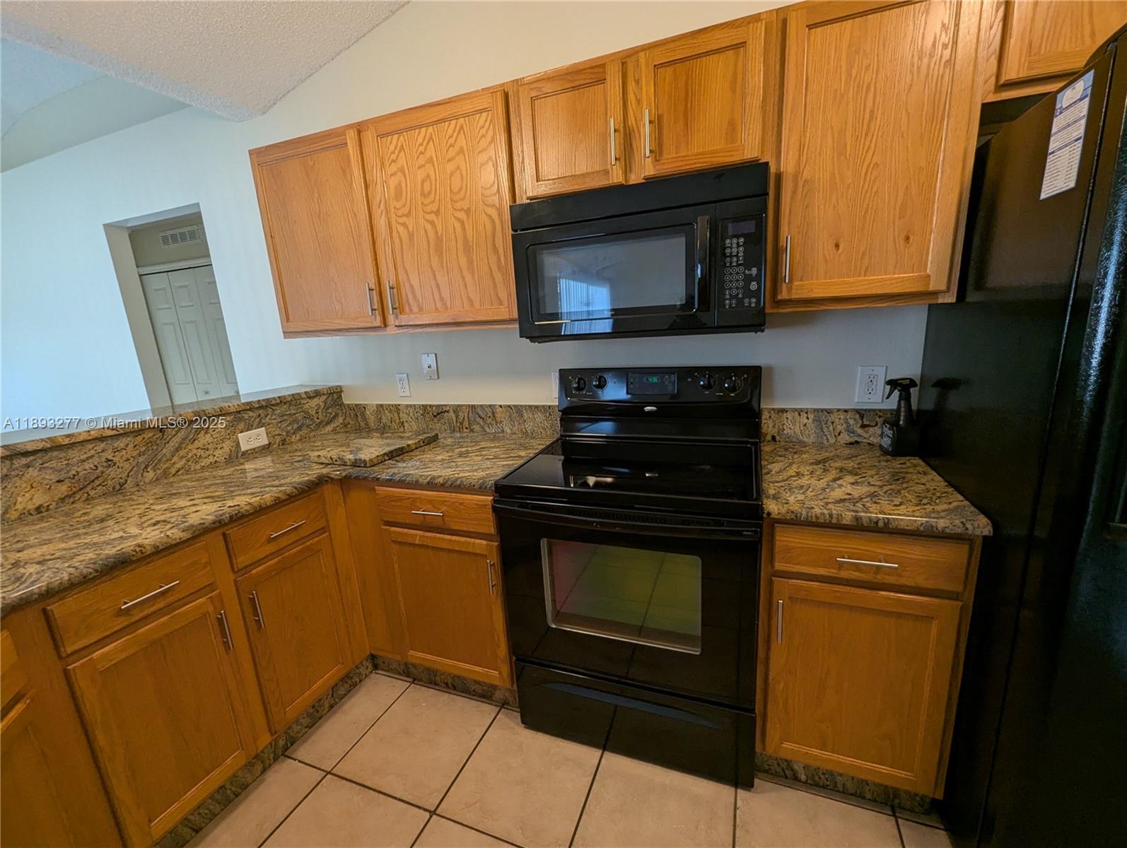 78 Pine Grove Drive Palm Coast, FL 32164 - Photo 17 of 49 a kitchen with granite countertop a stove top oven microwave and cabinets