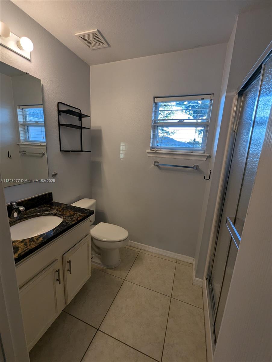 78 Pine Grove Drive Palm Coast, FL 32164 - Photo 48 of 49 a bathroom with a granite countertop toilet a sink and a mirror