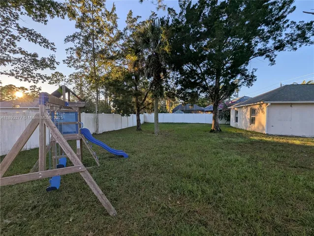 a kitchen with granite countertop a refrigerator a stove top oven and cabinets