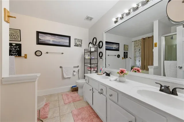 a bathroom with a double vanity sink mirror and shower