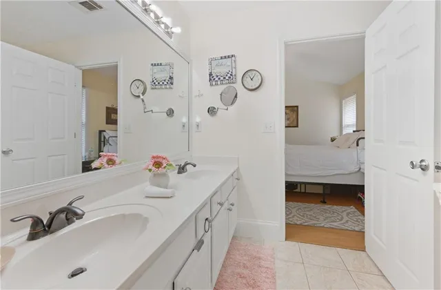 a en suite bathroom with a double vanity sink a mirror and a bathtub