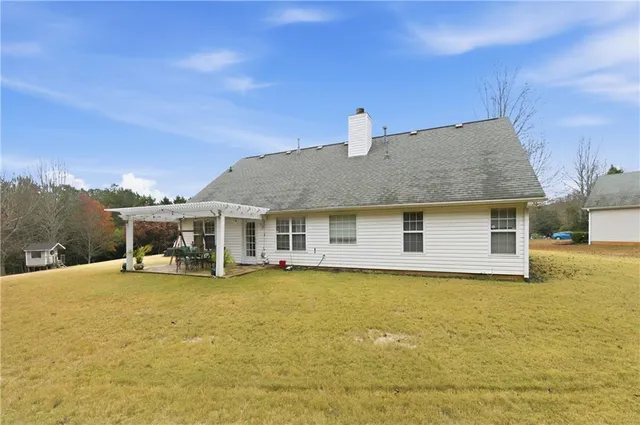 a front view of house with yard and trees in the background