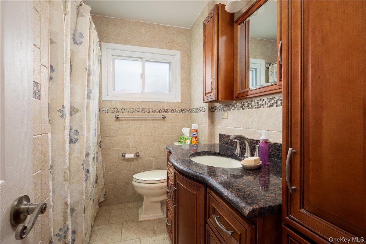 11 Adelphi Road Hicksville, NY 11801 - Photo 13 of 26 a bathroom with a granite countertop sink a toilet and shower