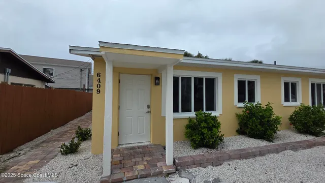 front view of house with potted plants