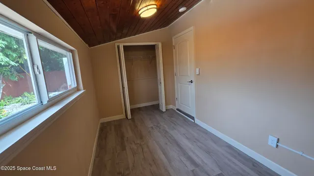 a view of a hallway with wooden floor and a window