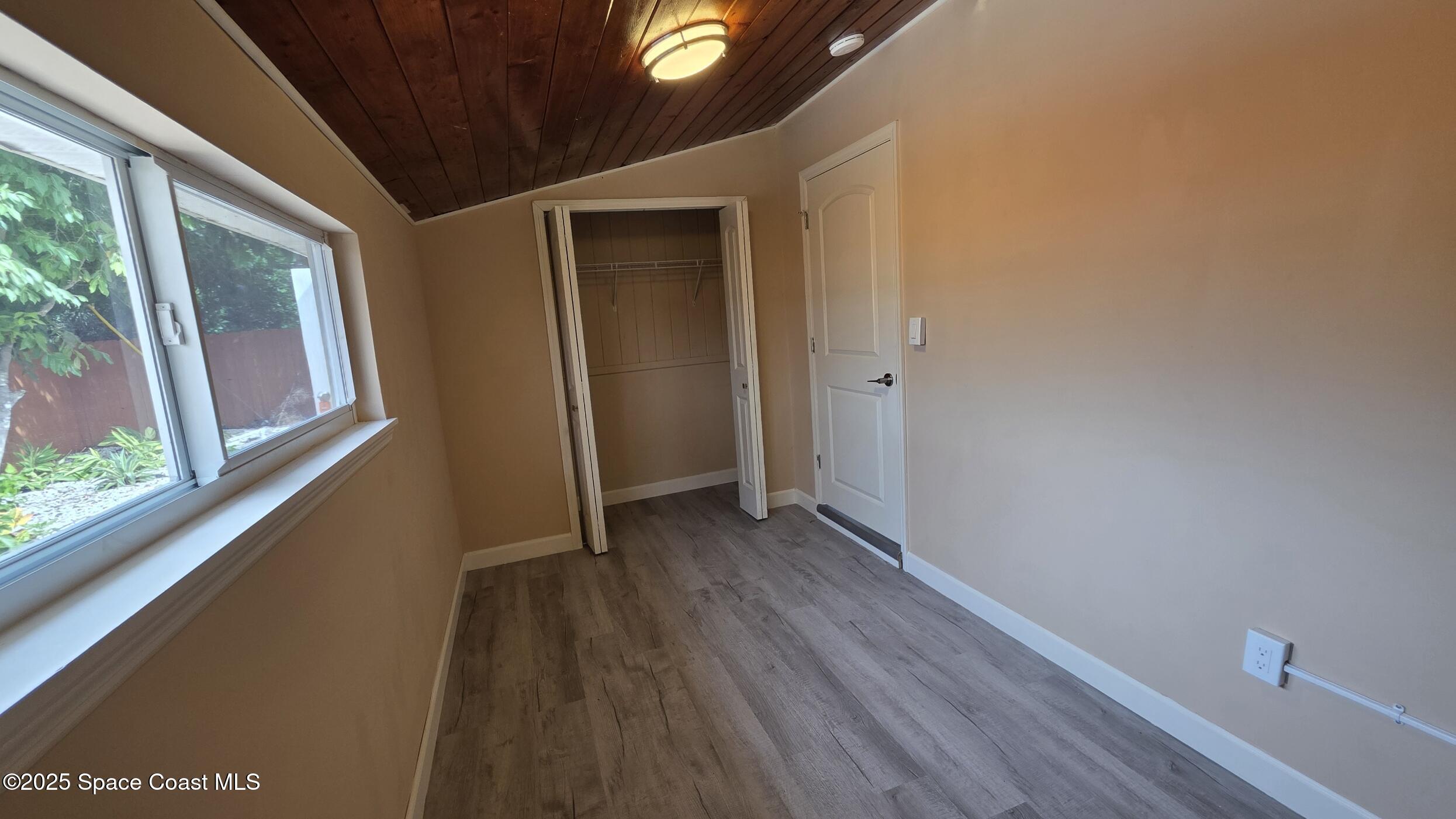 6409 Ridgewood Avenue Cocoa Beach, FL 32931 - Photo 11 of 17 a view of a hallway with wooden floor and a window