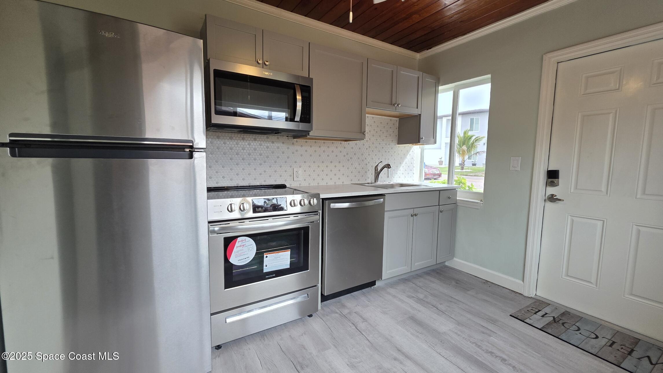 6409 Ridgewood Avenue Cocoa Beach, FL 32931 - Photo 2 of 17 a kitchen with stainless steel appliances granite countertop a stove a microwave and a refrigerator