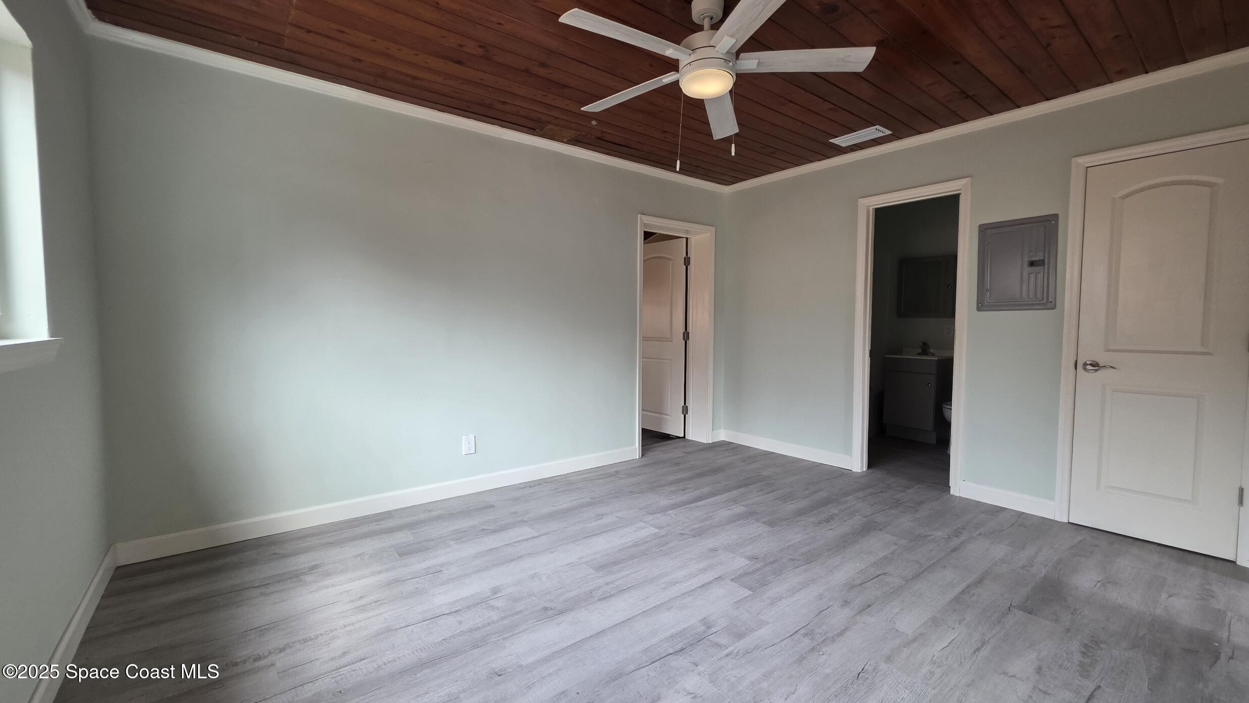 6409 Ridgewood Avenue Cocoa Beach, FL 32931 - Photo 3 of 17 an empty room with wooden floor closet and fan
