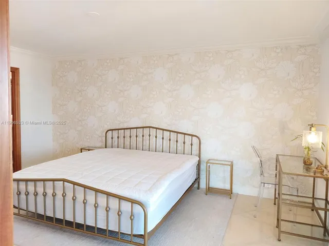 a large bed sitting in a bedroom next to a window