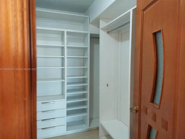 a view of walk in closet with empty racks