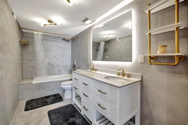a bathroom with a double vanity sink toilet mirror and bathtub