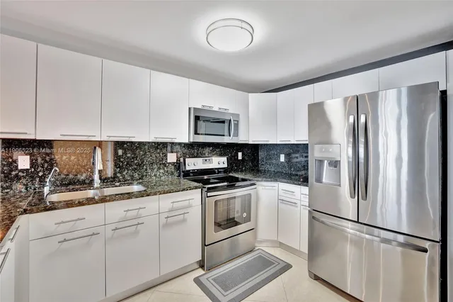 a kitchen with stainless steel appliances granite countertop a refrigerator sink and stove