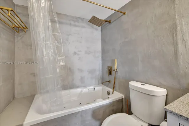 a white toilet sitting next to a bath tub and a shower