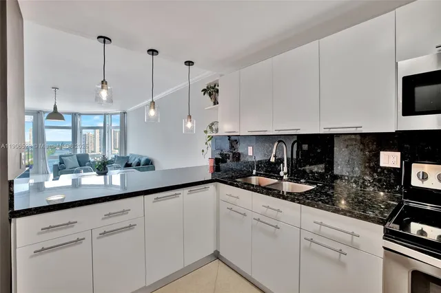 a kitchen with kitchen island granite countertop white cabinets and white appliances