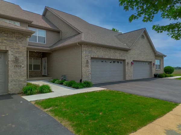 a front view of a house with a garden and plants
