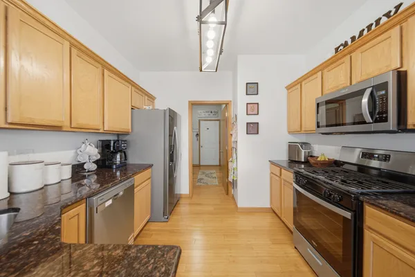 a kitchen with stainless steel appliances granite countertop a stove a sink and a microwave