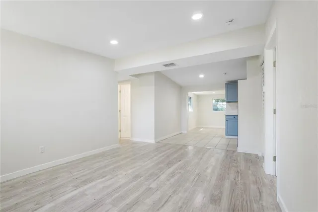 a view of a big room with wooden floor and a window