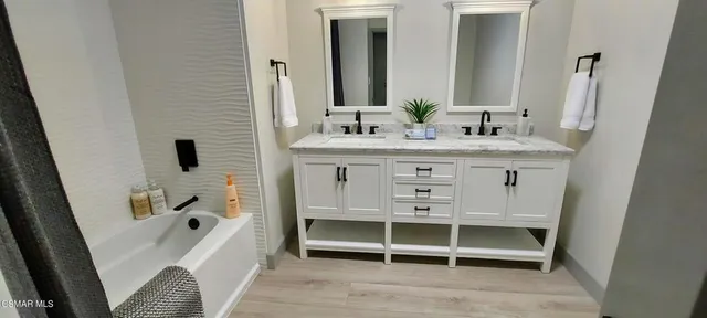 a bathroom with a tub sink and mirror
