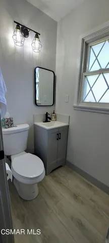 a bathroom with a toilet a sink and mirror