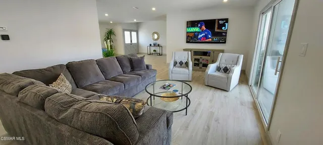 a living room with furniture a flat screen tv and a fireplace