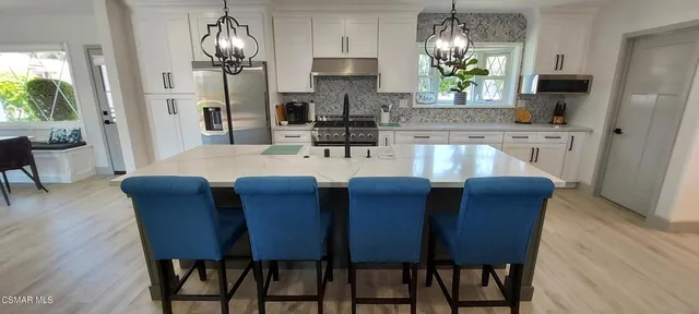 a dining room with furniture a chandelier and wooden floor