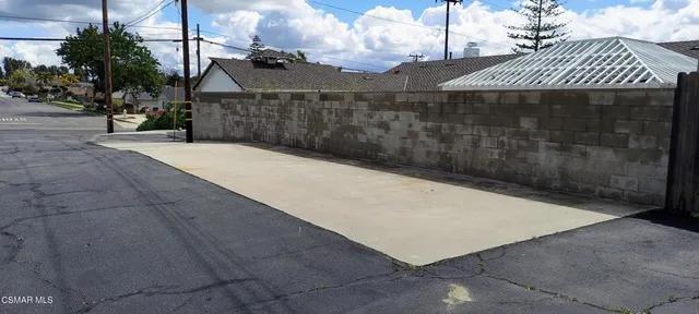 a view of backyard with barbeque grill and wooden fence