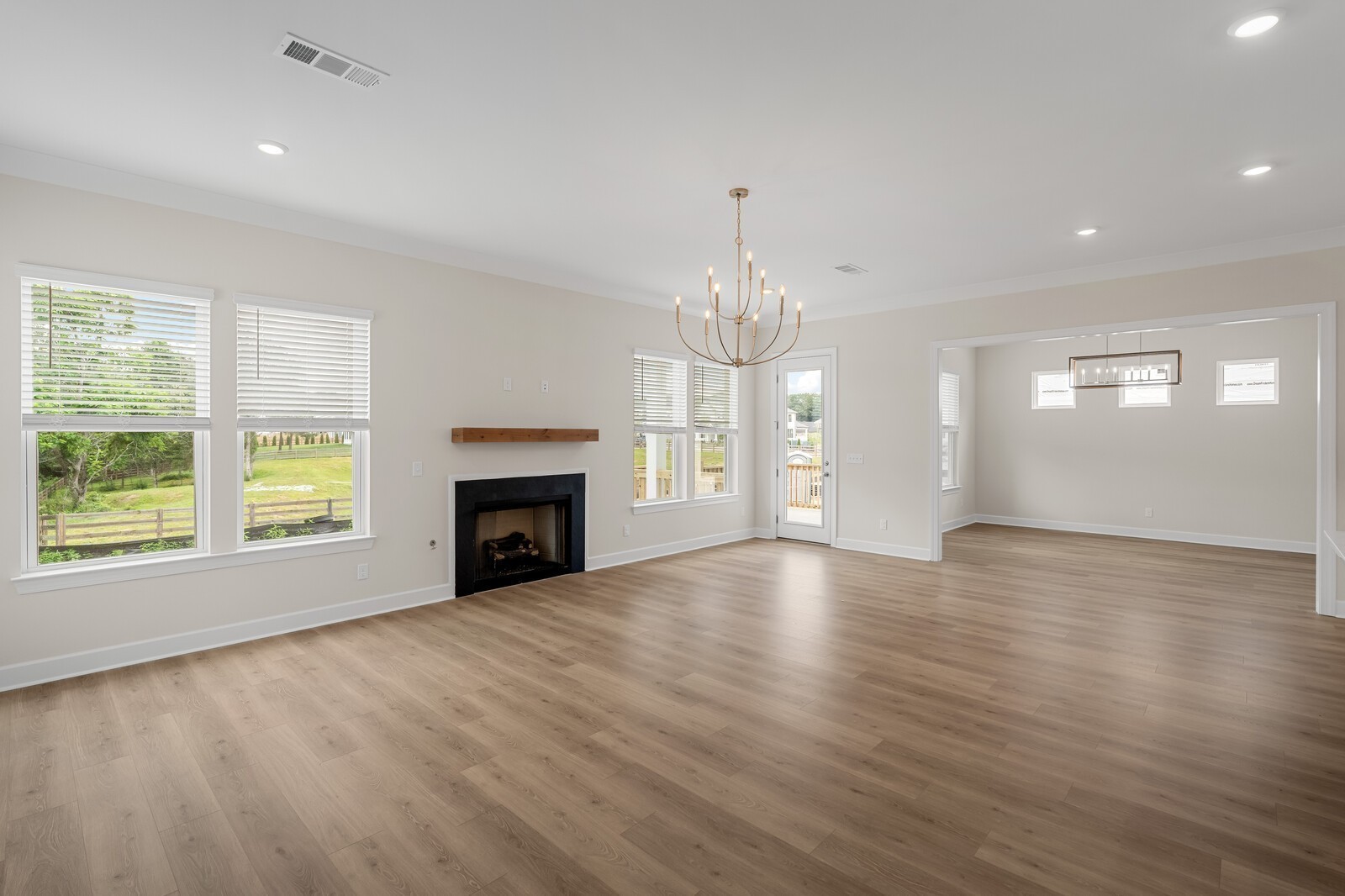 7456 Atwater Circle Fairview, TN 37062 - Photo 19 of 49 an empty room with wooden floor chandelier and fireplace
