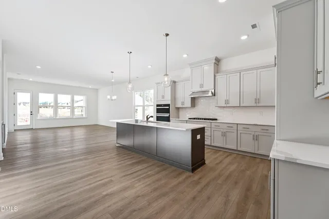 a kitchen with stainless steel appliances granite countertop a large window a sink and a refrigerator