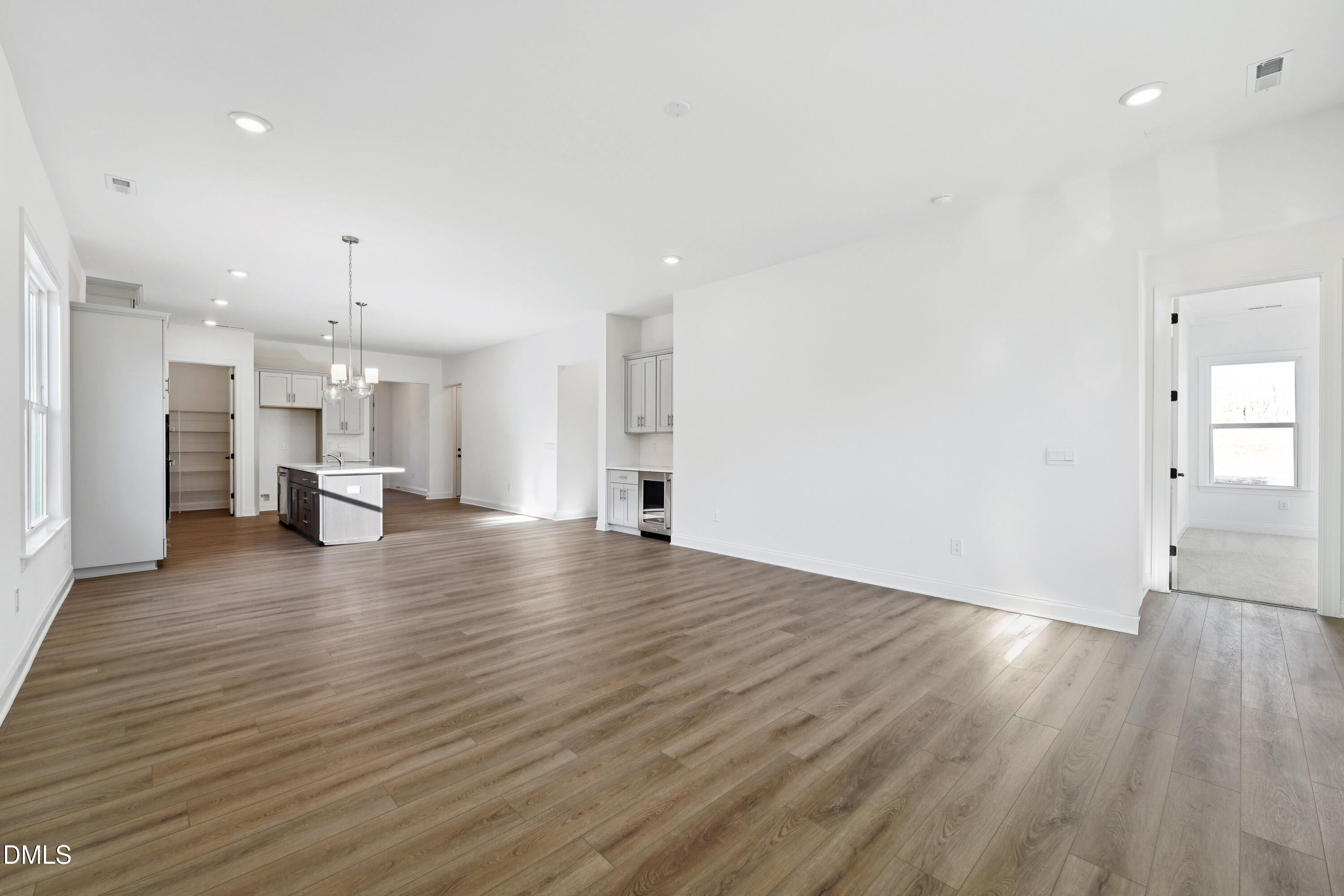 1157 Betula Road, Unit 109 Raleigh, NC 27610 - Photo 6 of 12 a view of an empty room with wooden floor kitchen view and a window