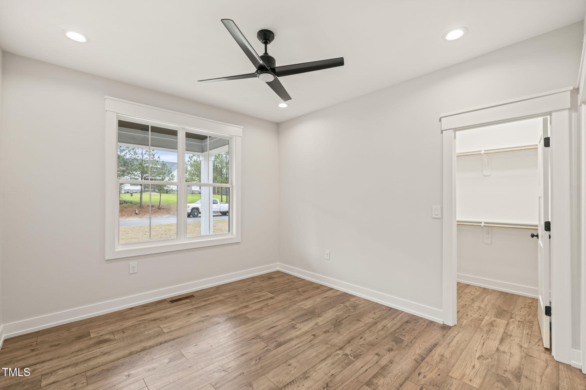 265 Pilot Ridge Road Zebulon, NC 27597 - Photo 11 of 53 an empty room with wooden floor ceiling fan and windows