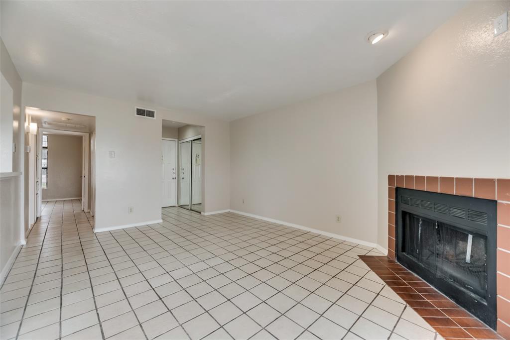 4544 Chaha Road, Unit 106 Garland, TX 75043 - Photo 7 of 17 Unfurnished living room with a fireplace and light tile flooring
