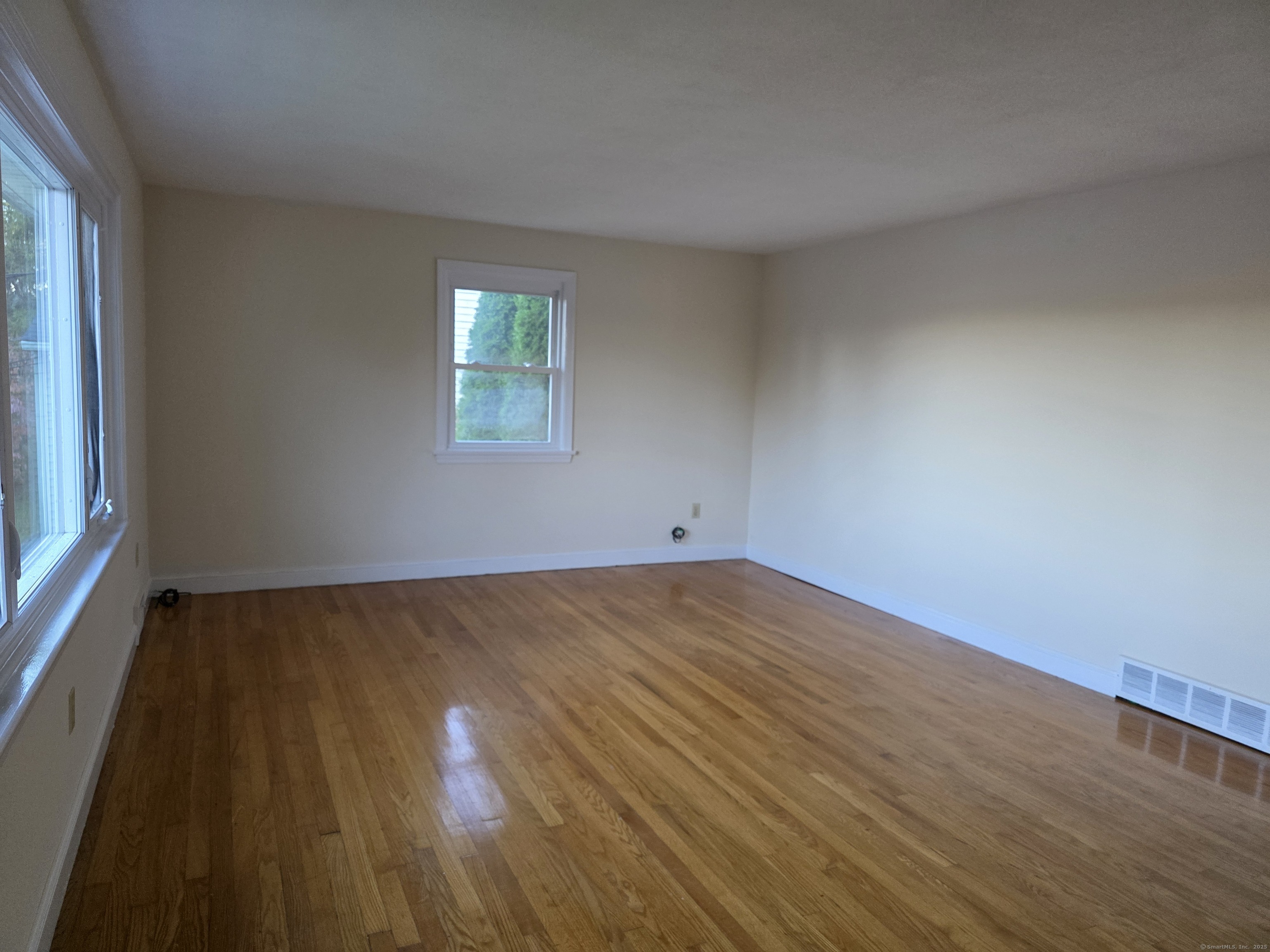 481 Bunker Hill Avenue Waterbury, CT 06708 - Photo 2 of 14 an empty room with wooden floor and windows