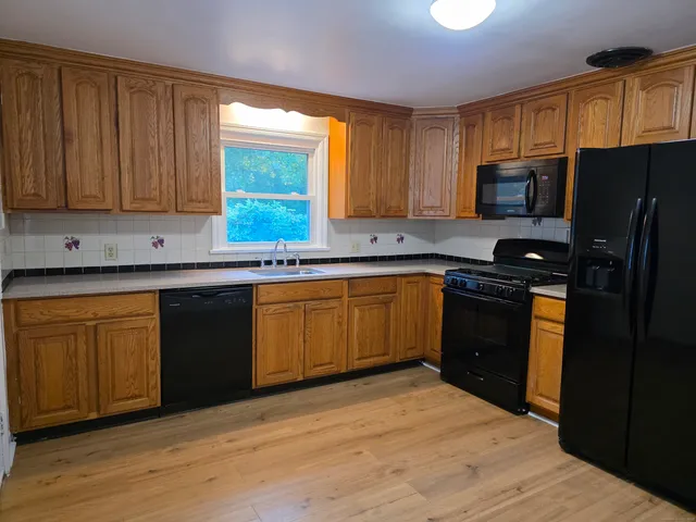 a kitchen with a sink stove top oven and refrigerator