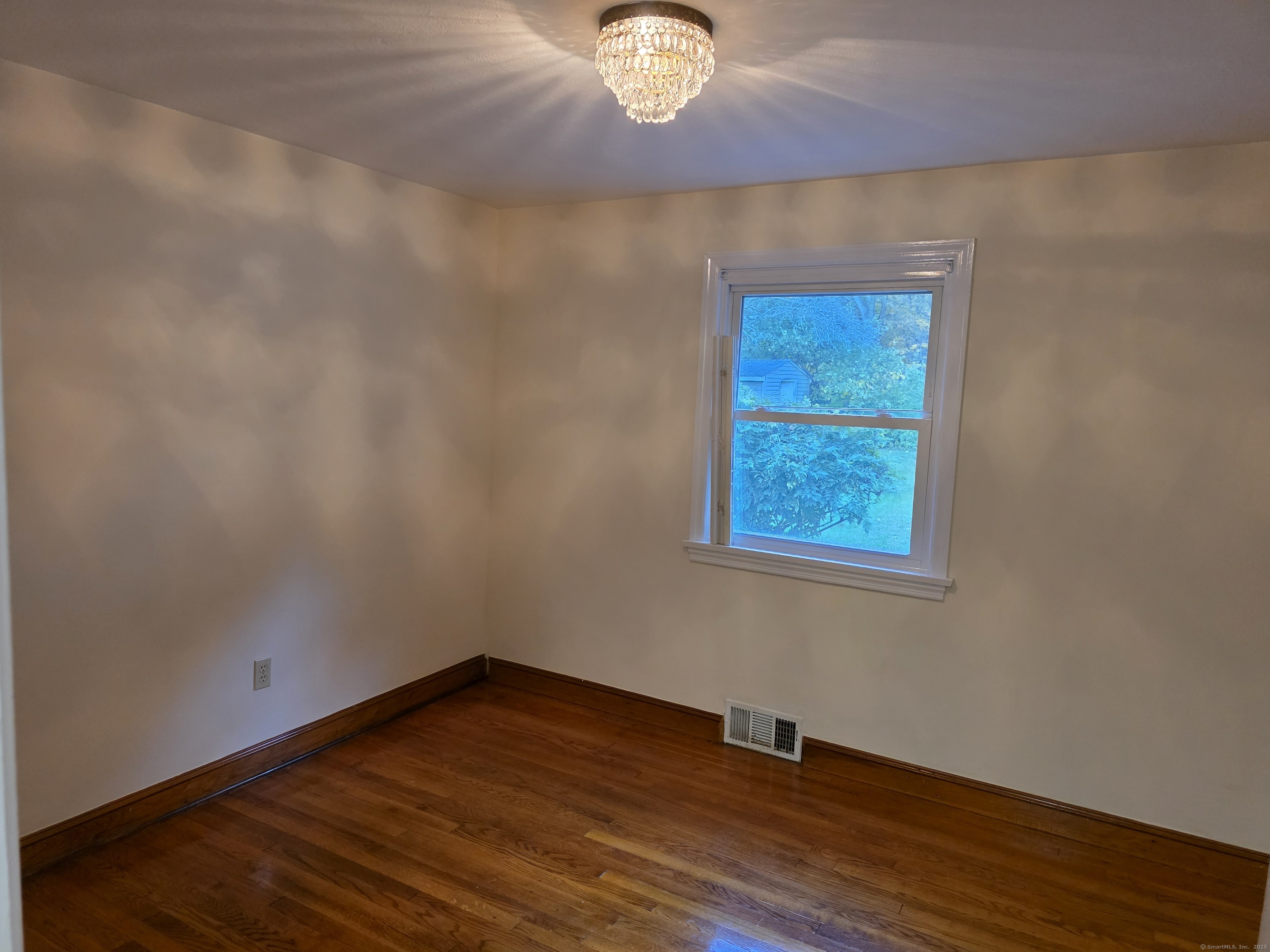 481 Bunker Hill Avenue Waterbury, CT 06708 - Photo 5 of 14 a view of an empty room with wooden floor and a window