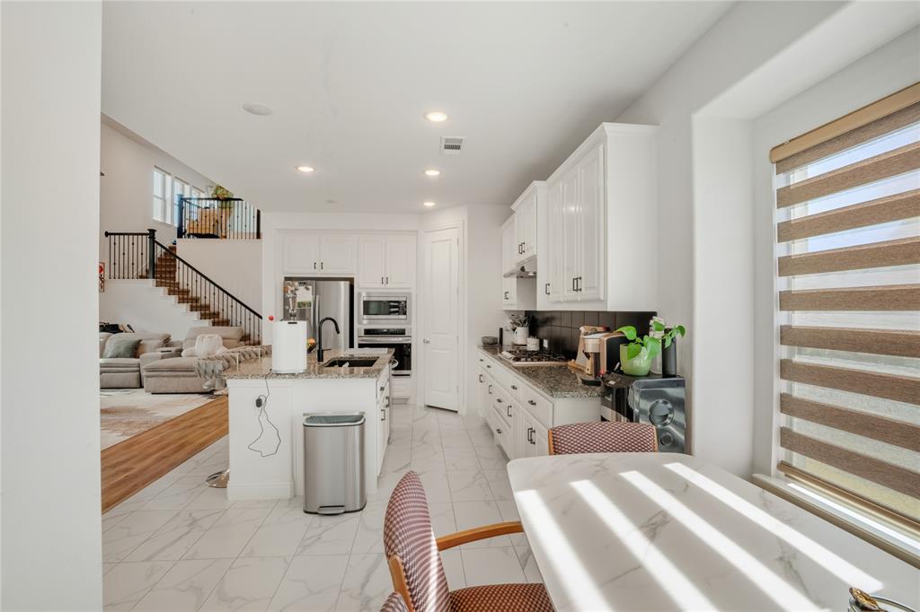 4424 English Maple Drive Arlington, TX 76005 - Photo 14 of 40 a kitchen with stainless steel appliances kitchen island granite countertop a refrigerator and a sink
