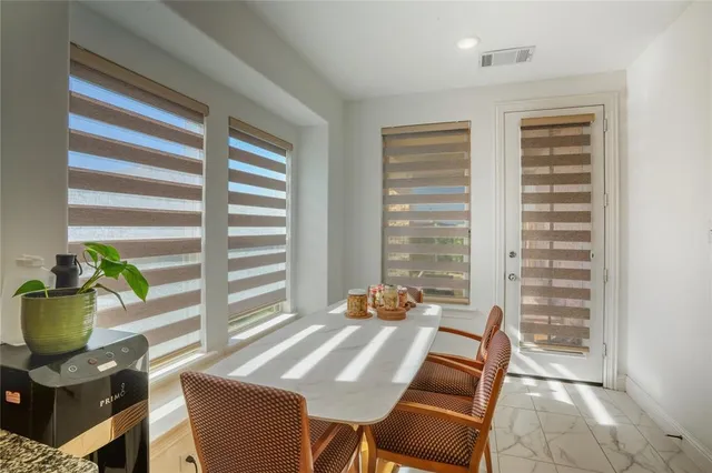 a view of a dining room with furniture and a potted plant