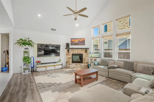 a living room with furniture a flat screen tv and a fireplace
