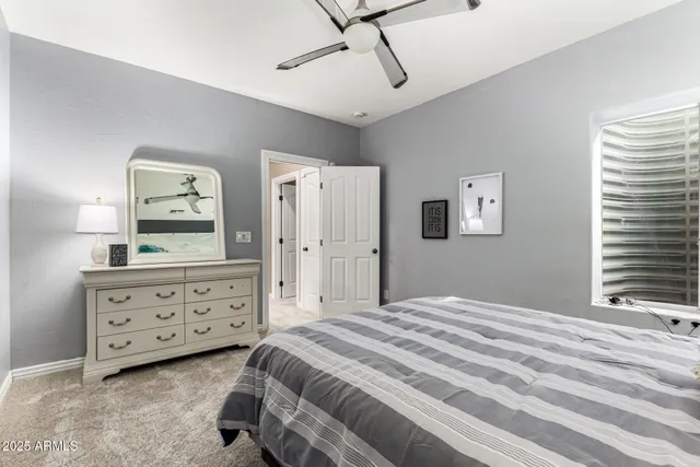 a bedroom with a bed a dresser and a window