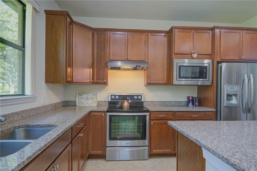 5211 Ciatto Way Ave Maria, FL 34142 - Photo 11 of 31 a kitchen with stainless steel appliances granite countertop a sink stove and refrigerator