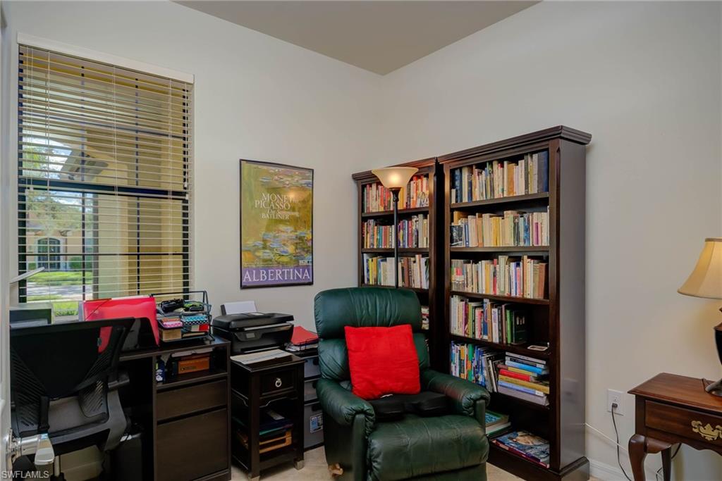 5211 Ciatto Way Ave Maria, FL 34142 - Photo 19 of 31 a living room with furniture and a book shelf