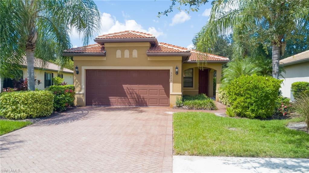 5211 Ciatto Way Ave Maria, FL 34142 - Photo 26 of 31 a front view of a house with a garden and palm trees