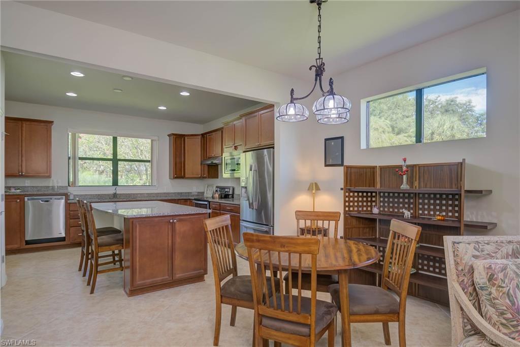 5211 Ciatto Way Ave Maria, FL 34142 - Photo 7 of 31 a dining room with a wooden table and chairs