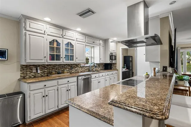 a large kitchen with stainless steel appliances granite countertop a sink and cabinets
