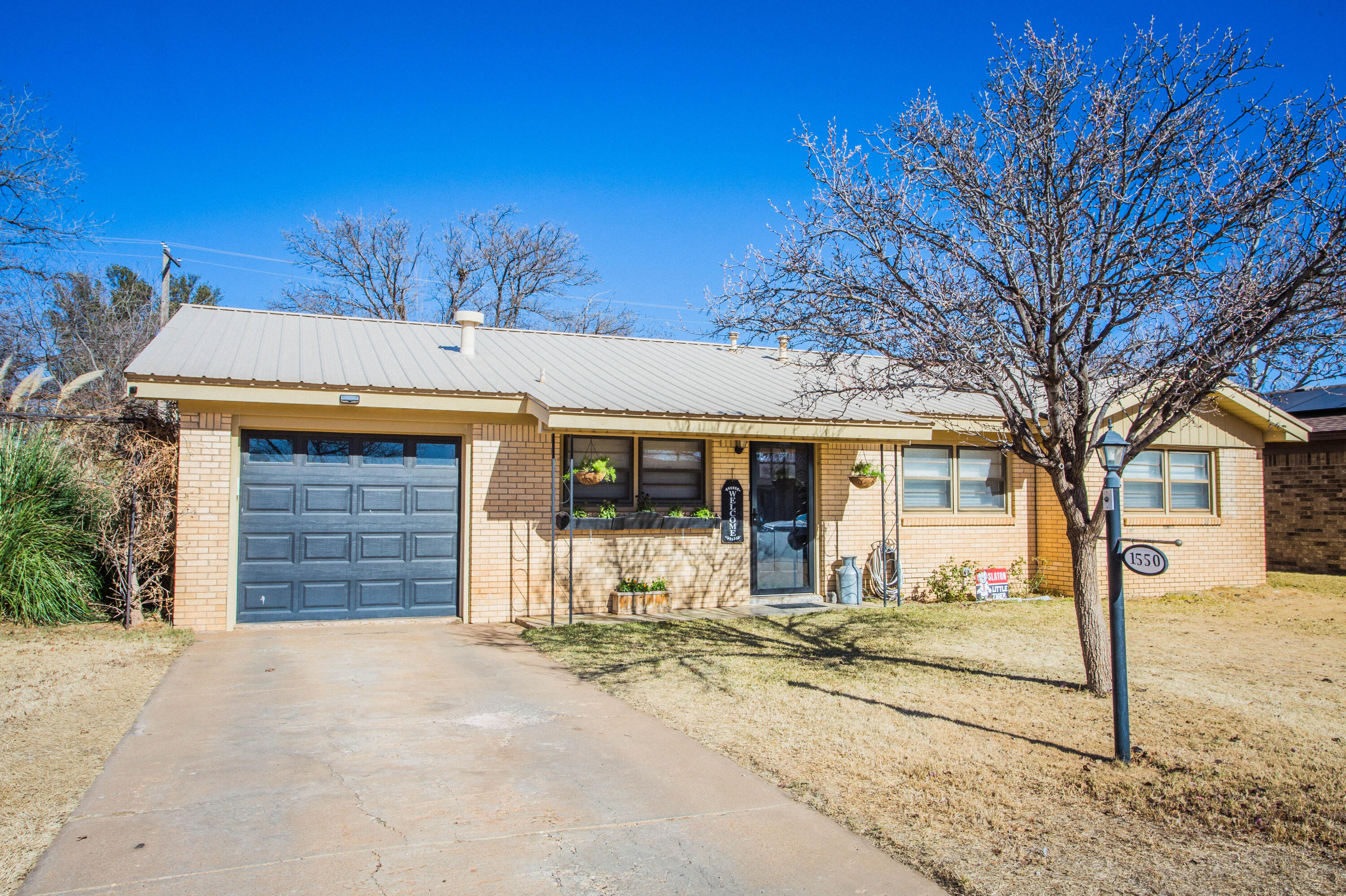 1550 West Lynn Street Slaton, TX 79364 - Photo 1 of 54 a front view of a house with a yard and garage