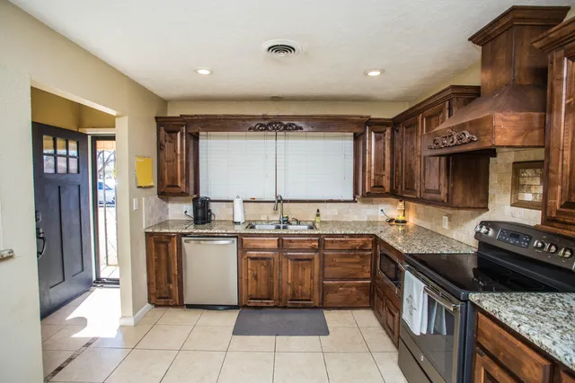 a kitchen with stainless steel appliances granite countertop a sink and a stove